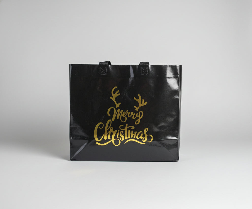 Black tote bag with gold 'Merry Christmas' text and reindeer antlers on a white background